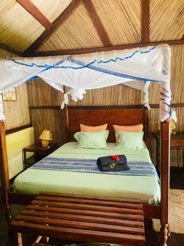 a bedroom with a bed with a canopy at Chambres d'hôtes Villa Les Orchidées Chez Ago in Sainte Marie