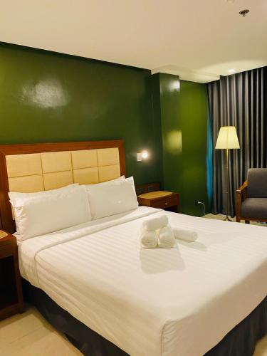 a bedroom with a large white bed with a green wall at Hotel Herencia 625 in Locsin