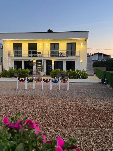 a house with red white and blue flags in front of it at TaNa's Apartments in Donji Štoj