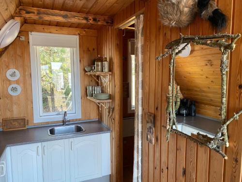 a kitchen with a sink and a window in a cabin at Hedebo Strand Camping in Sæby
