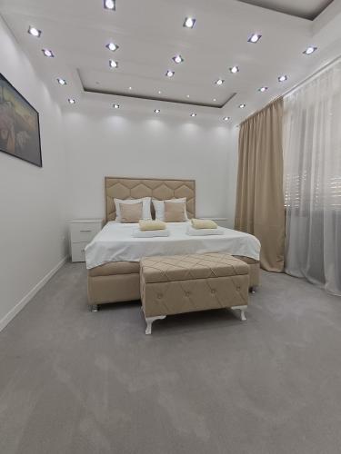 a white bedroom with a large bed and a large window at Prenociste T-07 in Smederevo