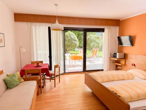 a bedroom with a bed and a dining room with a table at Residence Gerold in Rablà
