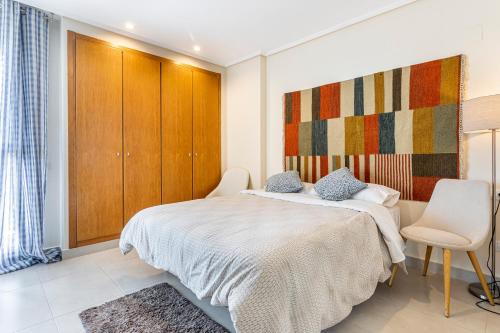 a bedroom with a bed and two chairs in it at Patacona By The Beach in Valencia