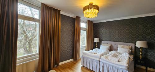 ein Schlafzimmer mit einem Bett und einem Kronleuchter in der Unterkunft Centralhotellet Söderhamn in Söderhamn