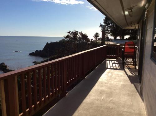 a balcony of a house with a view of the ocean at Mermaid's Muse Bed and Breakfast in Brookings