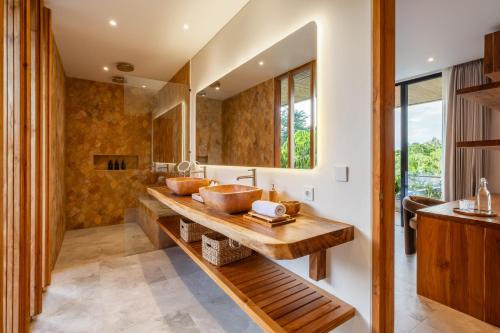 a bathroom with a wooden sink and a large mirror at Uluwatu Zen Villas in Badung