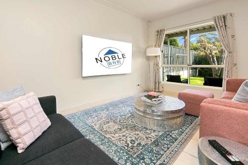 a living room with a couch and a coffee table at Archie's Townhouse 4BD 2BT in Glenunga
