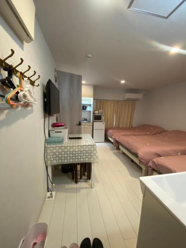 a room with two beds and a table in it at Hotel MR TOMO ATAMI 301 in Atami