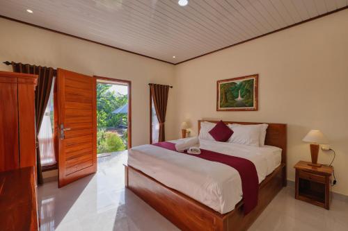 a bedroom with a large bed and a window at Lungguh Penida Hut in Nusa Penida