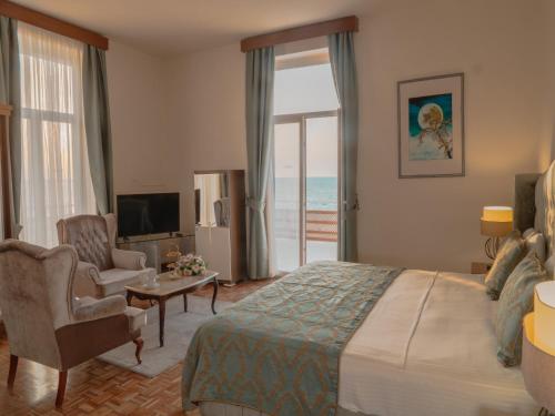 a hotel room with a bed and a living room with a window at Dome Hotel in Kyrenia