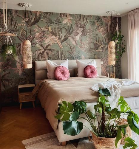 a bedroom with a large bed with pink pillows at B&B De Rooman in Sint-Gillis-Waas