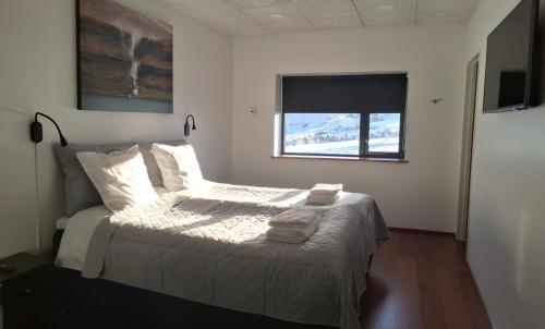 a bedroom with a bed with two towels on it at Penthouse by Krambatangi in Øravík