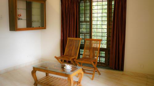 a living room with two chairs and a coffee table at Haven Grace in Kovalam