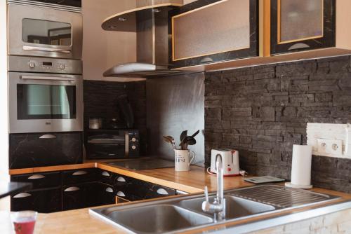 a kitchen with a sink and a counter top at Square'71 - T4 Duplex avec terrasse - espace détente in Chalon-sur-Saône