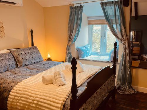 a bedroom with a large bed with a window at The Hideaway in Tintagel