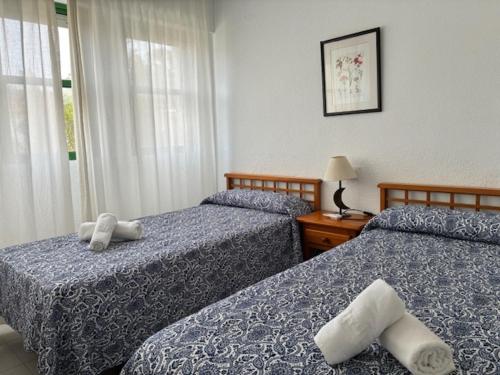 a bedroom with two beds and a window at Apartamentos Torrelaguna in Vera