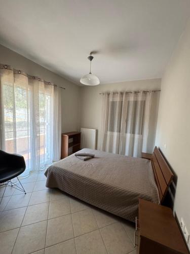a bedroom with a bed and a desk and window at Relaxivng home 2 in Konístrai