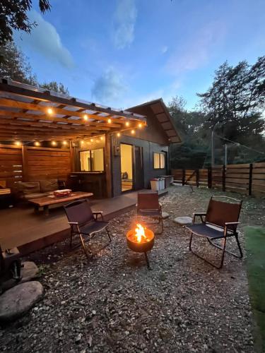 a backyard with a fire pit and chairs and a house at Forest 99 in Nasushiobara
