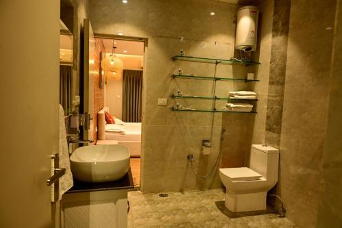 a bathroom with a toilet and a sink and a shower at Serenity by the Sea Goa in Silidao