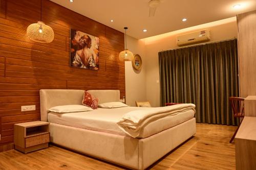 a bedroom with a large bed and wooden walls at Serenity by the Sea Goa in Silidao
