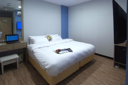 a bedroom with a large bed and a television at Mei Ti Fashion Hotel in Zhongli