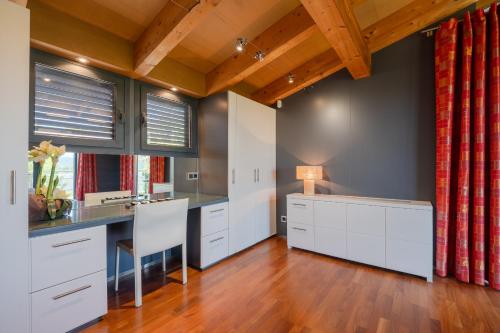 a kitchen with white cabinets and a table with a chair at Flateli Palau 1 in Girona