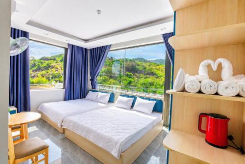 a bedroom with a bed and a large window at Đức Loan Hotel Vĩnh Hy in Ninh Hải