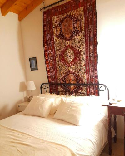 a bedroom with a bed with a rug on the wall at Ble Mavi - Studio for 2 in Vouni