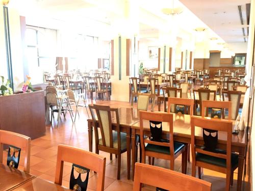 a dining room with wooden tables and chairs at Kobe Hotel Fruit Flower in Kobe