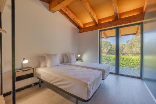 a bedroom with two beds and a large window at Flateli Palau 2 in Girona