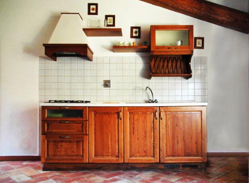 a kitchen with wooden cabinets and a sink at Locanda Le Isole in Poggio al Pozzo