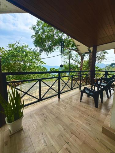 a porch with benches and a view of the water at Wind Bells in Anaviratty
