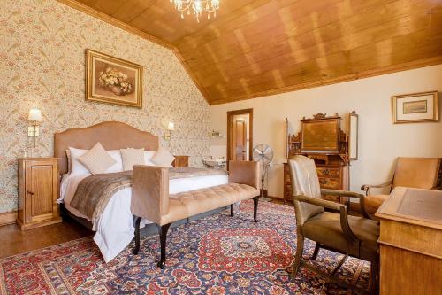 a bedroom with a bed and a table and chairs at Portland Manor in Knysna