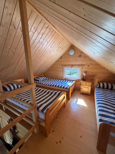 a room with two bunk beds in a log cabin at Kotwicownia in Mikołajki