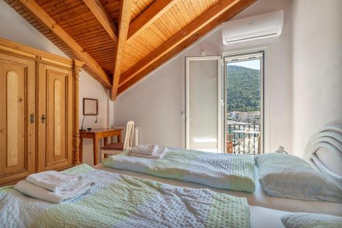 a bedroom with a bed and a window with a view at Pilali Apartments Greece in Agia Effimia