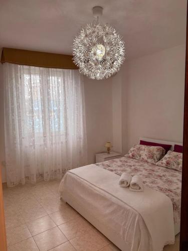 a bedroom with a large bed with a chandelier at La Puteca di Nonna Cia in Andrano