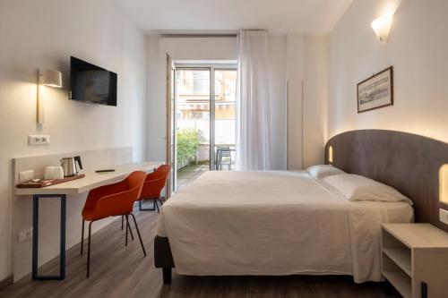 ein Hotelzimmer mit einem Bett, einem Schreibtisch und einem Tisch in der Unterkunft Hotel Piccolo in Verona