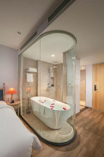 a bath tub in a room with a bedroom at Solar Premium Hotel & Spa in Hanoi