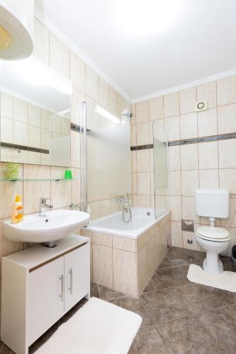 a bathroom with a sink and a toilet and a tub at Apartments Baltazar with Sea View&Jacuzzi in Dubrovnik