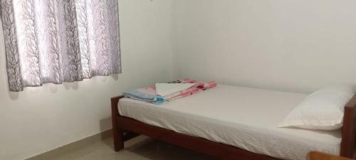 a bedroom with a bed with a box on it at Wind Bells in Anaviratty