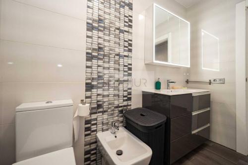 a bathroom with a white toilet and a sink at Pomar By Silastur in Obaya