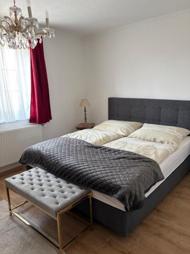 a large bed in a bedroom with a chandelier at Haus Erika in Gamlitz