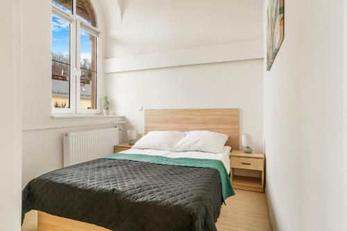 a bedroom with a bed and a window at Apartament Pierwszy Maj in Kudowa-Zdrój