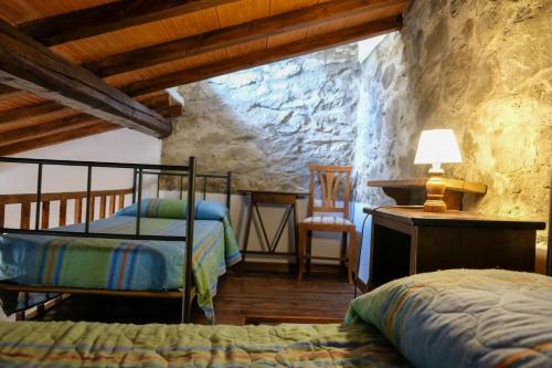 a bedroom with two beds and a desk and a chair at Locanda Le Isole in Poggio al Pozzo