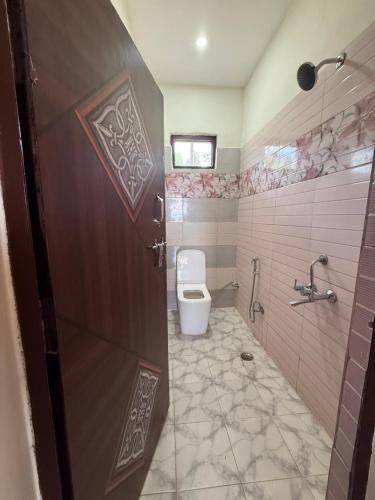 a bathroom with a toilet and a shower at Adhikari mountain view homestay in Chaubattia