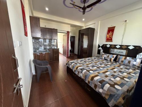 a bedroom with a bed and a chair in it at Adhikari mountain view homestay in Chaubattia