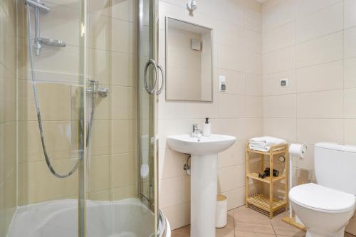 a bathroom with a shower and a sink and a toilet at Apartament Pierwszy Maj in Kudowa-Zdrój