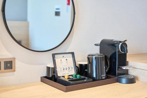 a counter with a coffee maker and a mirror at Chestertons Sokcho in Sokcho