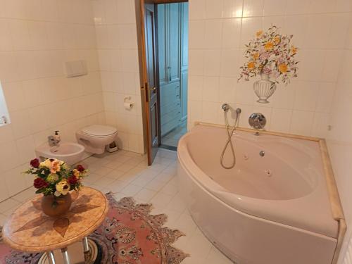 a bathroom with a tub and a toilet and a table at L'Antica Dimora Toscana in Cecina