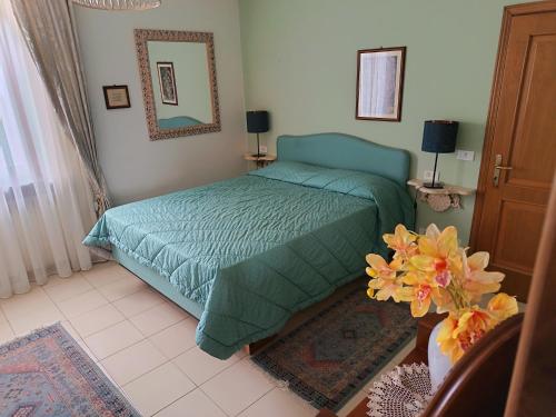 a bedroom with a bed with a green comforter at L'Antica Dimora Toscana in Cecina